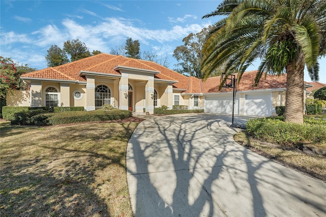 mediterranean / spanish-style home with a garage and a front yard