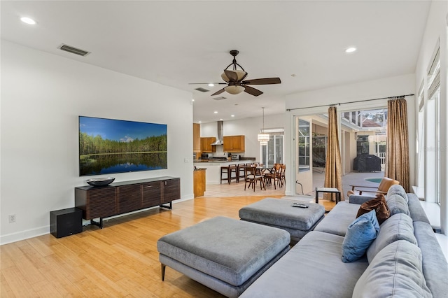 living room with ceiling fan and light hardwood / wood-style floors