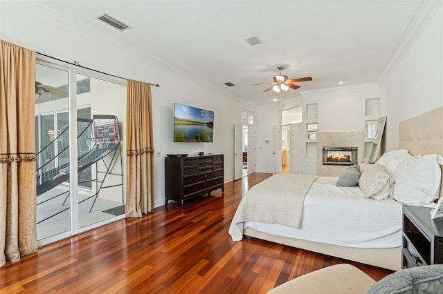 bedroom with a multi sided fireplace, dark hardwood / wood-style flooring, access to exterior, ceiling fan, and crown molding