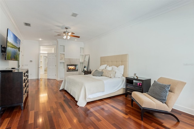 bedroom featuring ornamental molding, dark hardwood / wood-style floors, ceiling fan, and a multi sided fireplace