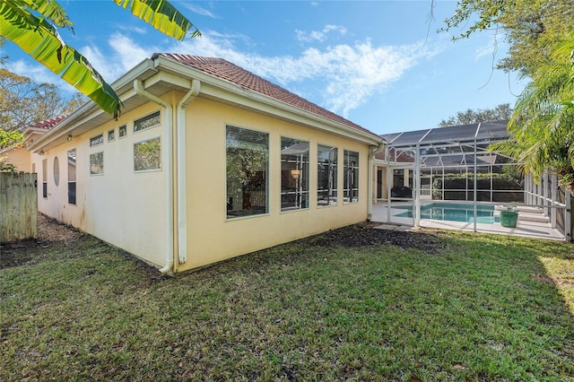 view of property exterior with a yard and glass enclosure