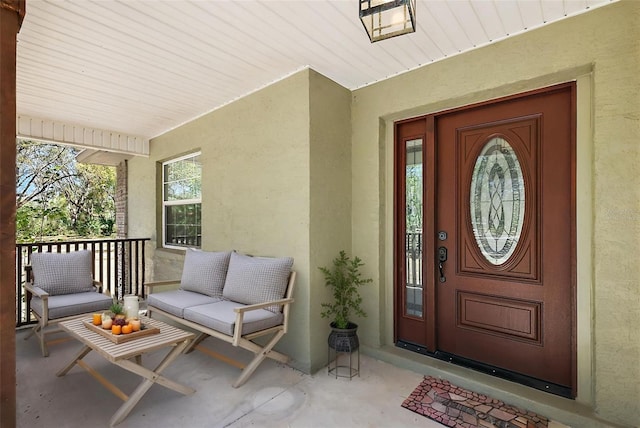 property entrance with covered porch and stucco siding