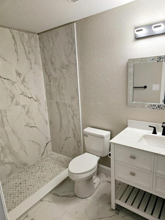 bathroom featuring vanity, a shower, toilet, and a textured ceiling