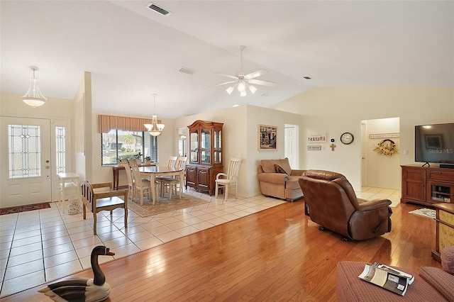 living room featuring ceiling fan, lofted ceiling, and light wood-type flooring