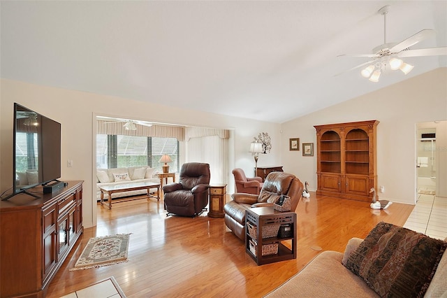 living room featuring ceiling fan, vaulted ceiling, and light wood-type flooring