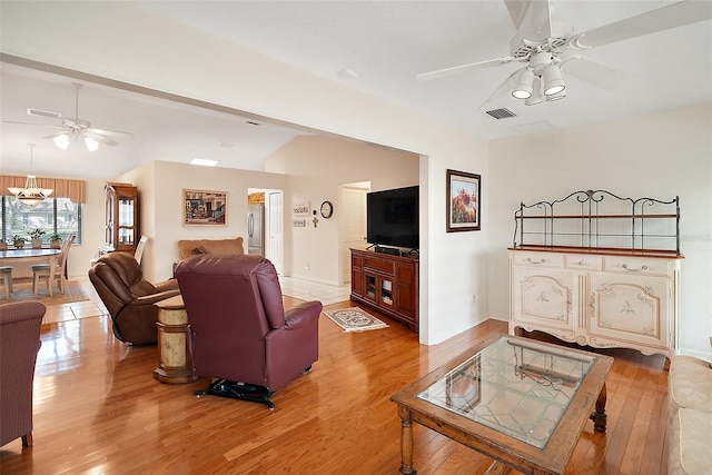 living room featuring lofted ceiling, hardwood / wood-style flooring, and ceiling fan