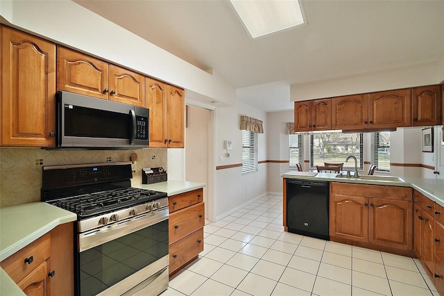 kitchen with light tile patterned flooring, sink, decorative backsplash, stainless steel appliances, and a healthy amount of sunlight