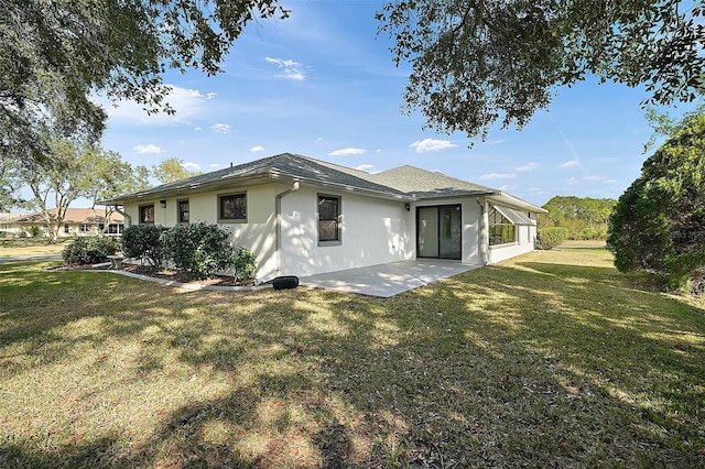 rear view of house featuring a patio area and a lawn