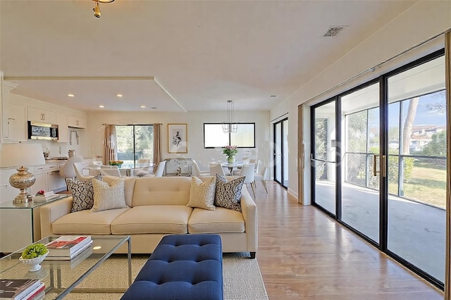 living room with visible vents, recessed lighting, and light wood-type flooring