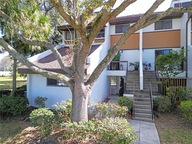 exterior space with stucco siding and stairs