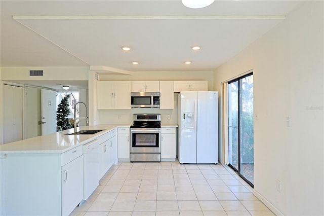 kitchen featuring sink, white cabinetry, appliances with stainless steel finishes, plenty of natural light, and kitchen peninsula