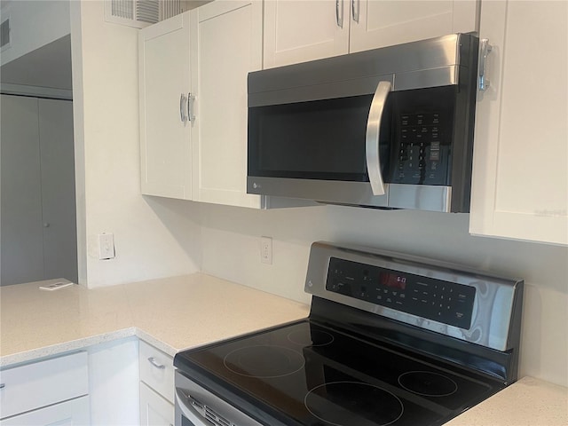 kitchen featuring white cabinetry, light stone countertops, and stainless steel appliances