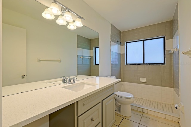 full bathroom with tile patterned floors, tiled shower, toilet, and vanity