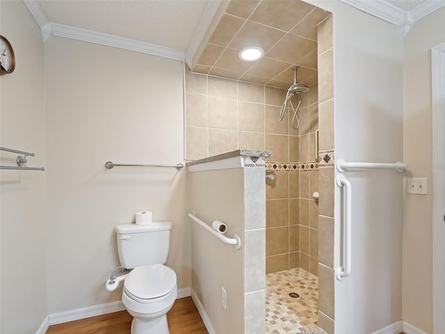 bathroom with hardwood / wood-style flooring, ornamental molding, tiled shower, and toilet