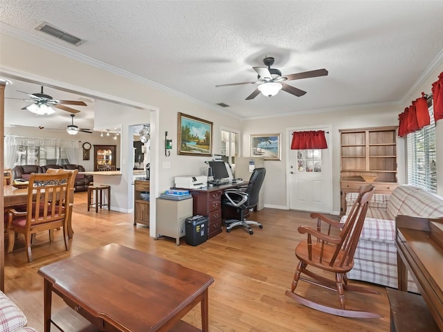 home office with crown molding, ceiling fan, light hardwood / wood-style floors, and a textured ceiling