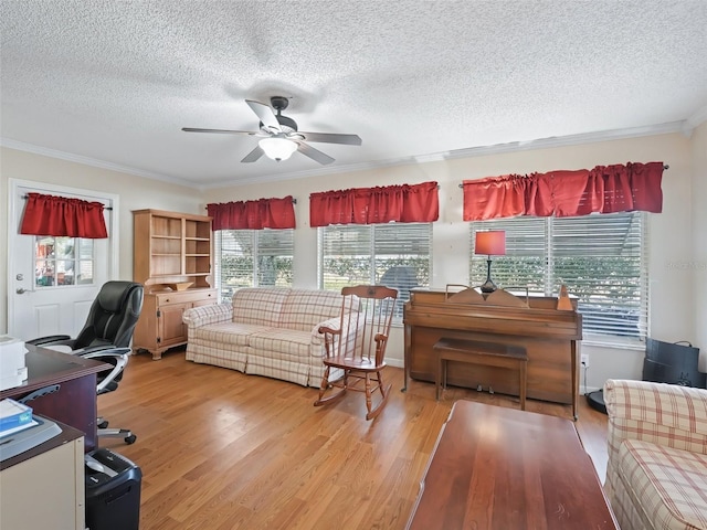 office space featuring crown molding, a wealth of natural light, ceiling fan, and light wood-type flooring