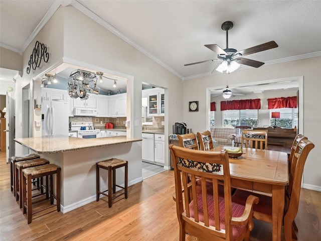 dining room featuring ceiling fan with notable chandelier, ornamental molding, and light wood-type flooring