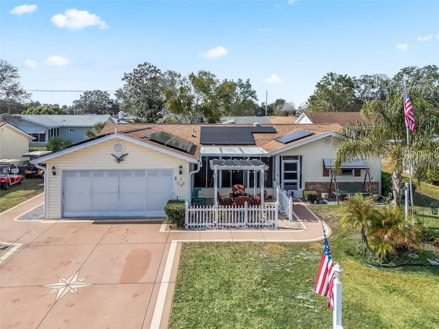 single story home with a garage, a front yard, and solar panels