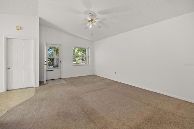 carpeted empty room featuring vaulted ceiling, a textured ceiling, and ceiling fan