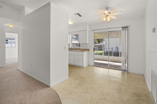 empty room with ceiling fan, sink, and a textured ceiling