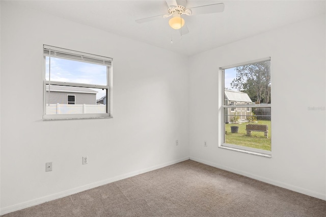 unfurnished room with ceiling fan, a healthy amount of sunlight, and carpet