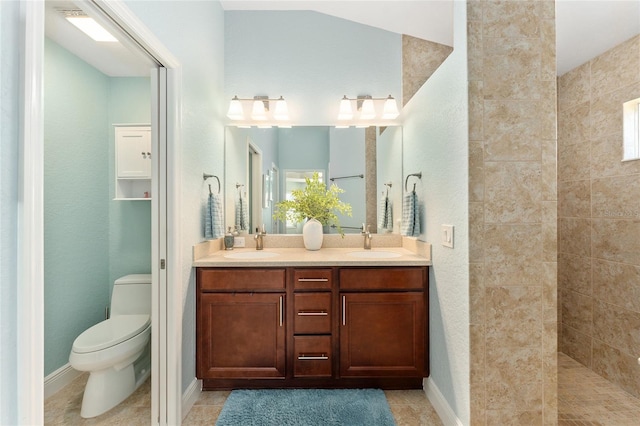 bathroom featuring vanity, tile patterned floors, toilet, and tiled shower