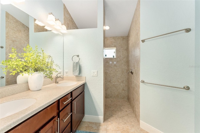 bathroom with vanity, tile patterned flooring, and a tile shower