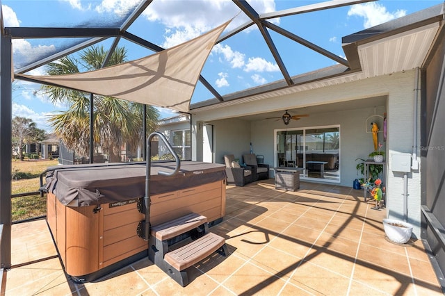 view of patio with ceiling fan, a hot tub, and glass enclosure