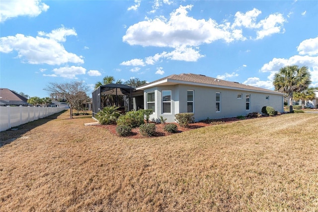 view of side of property with a lawn and glass enclosure