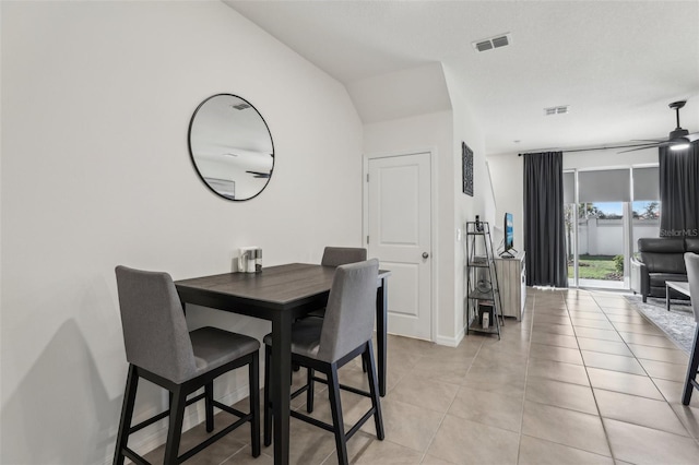 dining space with vaulted ceiling, light tile patterned floors, and ceiling fan