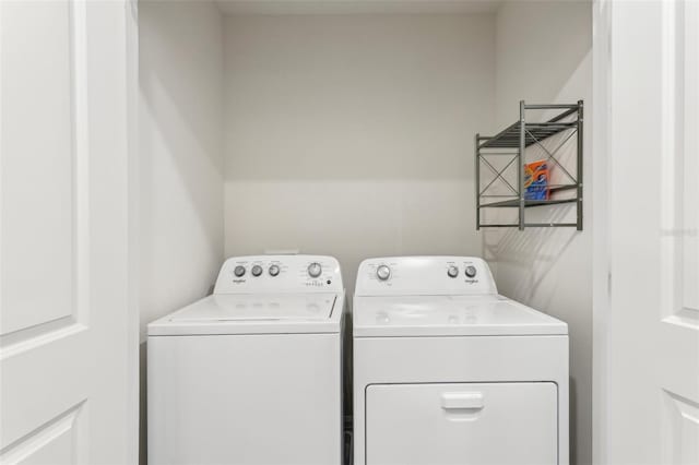 clothes washing area with washing machine and dryer