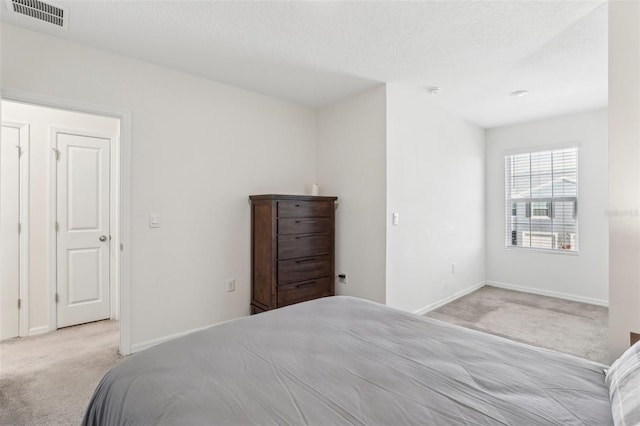 carpeted bedroom featuring a textured ceiling