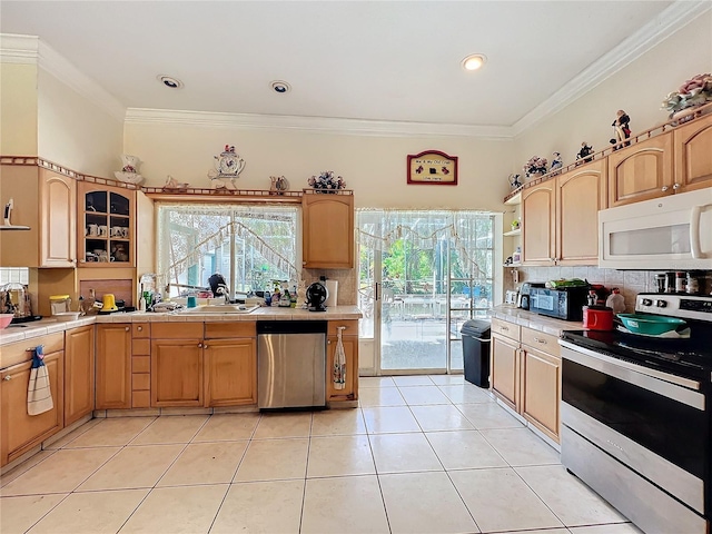 kitchen with crown molding, appliances with stainless steel finishes, and decorative backsplash