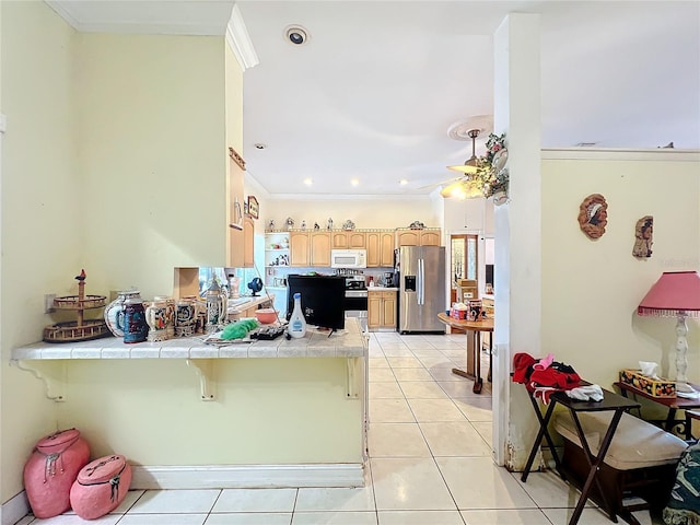 kitchen featuring light tile patterned floors, a breakfast bar area, appliances with stainless steel finishes, tile counters, and kitchen peninsula