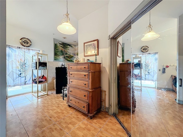 hallway with light tile patterned flooring and a high ceiling