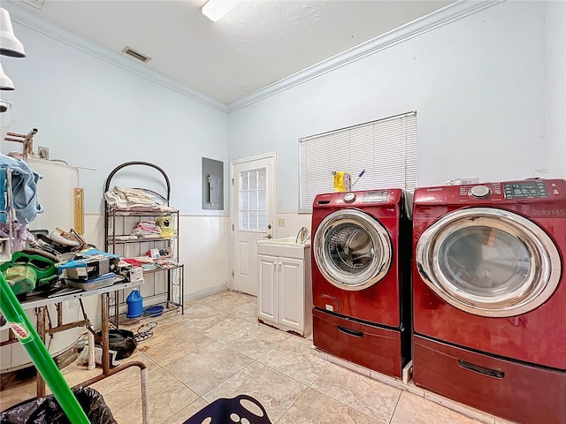 clothes washing area featuring crown molding, washing machine and dryer, cabinets, and electric panel