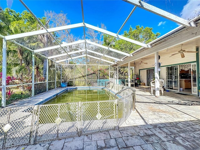 view of pool featuring ceiling fan, glass enclosure, and a patio area