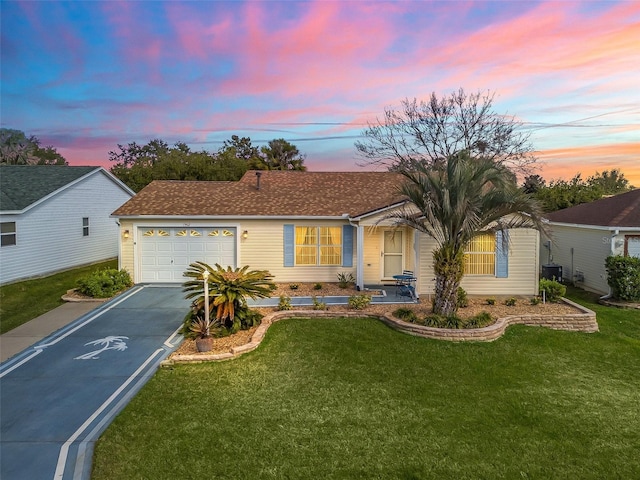 single story home with cooling unit, a garage, and a yard