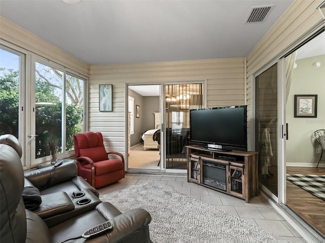 living room featuring light tile patterned floors and wood walls