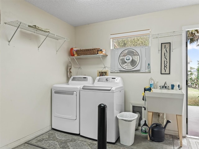 laundry area with independent washer and dryer and a textured ceiling