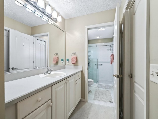 bathroom featuring vanity, toilet, an enclosed shower, and a textured ceiling