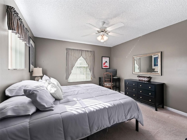 bedroom featuring ceiling fan, carpet, and a textured ceiling