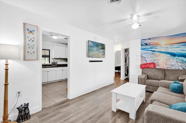 living room with ceiling fan and light wood-type flooring