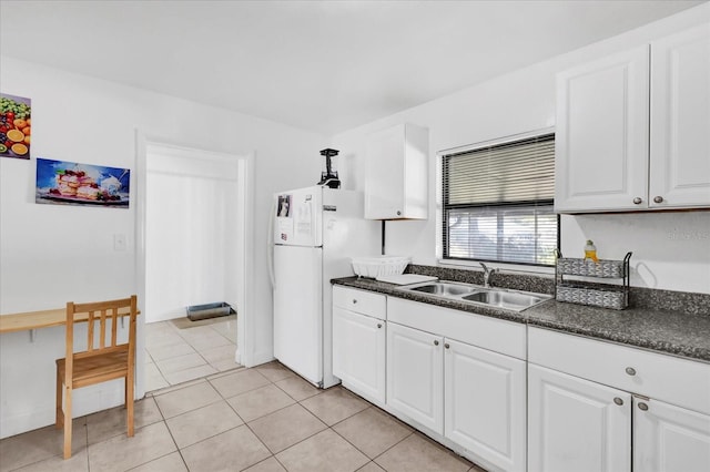 kitchen featuring white refrigerator, sink, and white cabinets