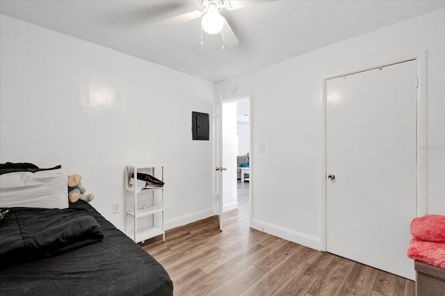 bedroom with ceiling fan, light hardwood / wood-style floors, and electric panel