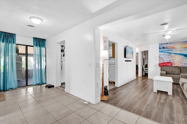 interior space featuring light tile patterned flooring, ceiling fan, and a textured ceiling