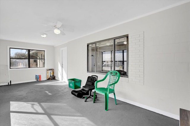 living area featuring ceiling fan and concrete flooring