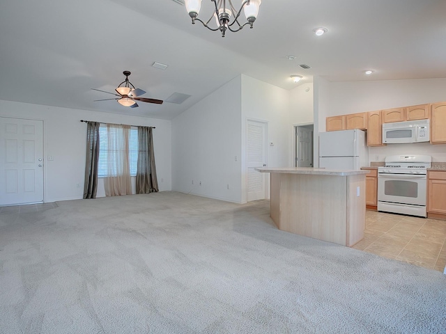 kitchen featuring pendant lighting, lofted ceiling, white appliances, a center island, and light brown cabinets