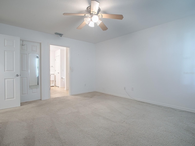 carpeted spare room featuring ceiling fan