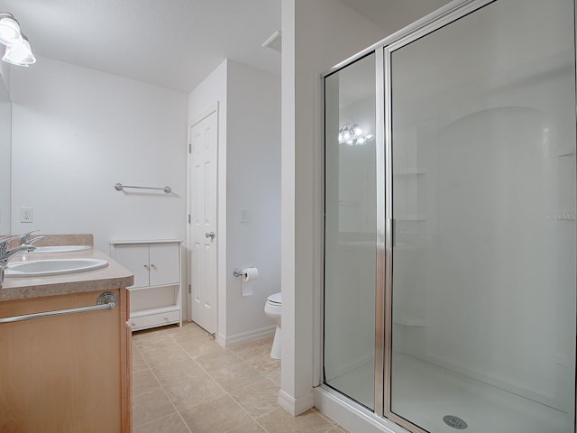 bathroom with tile patterned floors, vanity, toilet, and a shower with shower door